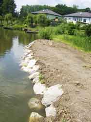 Uferbefestigung mit Granitblöcken die durch die Fa. Wintermit dem Bagger ins Erdreich gedrückt wurden.
